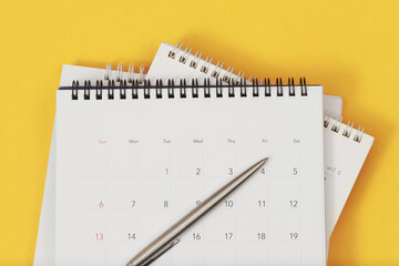 A pen with calendar on yellow background. - obrazy, fototapety, plakaty