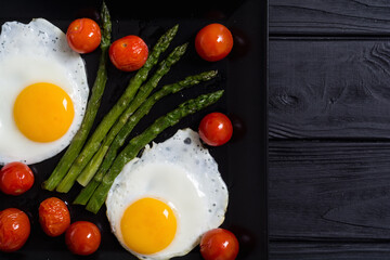 Healthy breakfast with eggs , asparagus and tomatoes