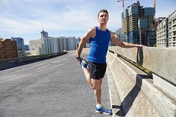 Man, stretching legs and running in city, warm up for cardio workout and fitness outdoor. Athlete, sports and runner in New York with health, wellness and ready for race or marathon on urban bridge - obrazy, fototapety, plakaty