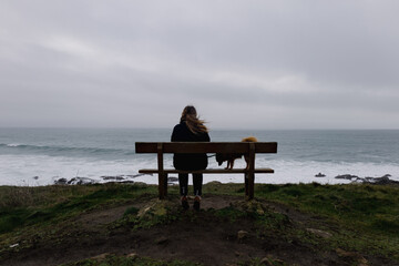 Une fille et son chien devant l'océan 