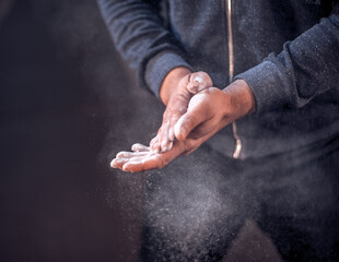 The athlete lubricated his hands with powder to engage in strength training. Preparation for training