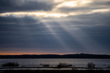 The sun's rays break through the clouds and illuminate the lake.
The picture was taken at Lake Burtnieks in Latvia.