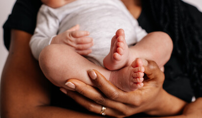 Mothers with newborn baby son, legs and hand
