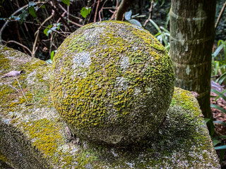 Moss-Covered Stone Sphere Amidst Natural Greenery
