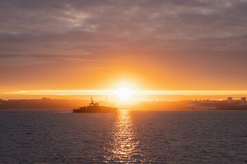 A military boat approaches Tallinn at dawn.