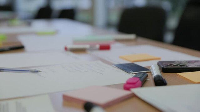 Office school table covered with paper and markers for creative idea generation in slow motion