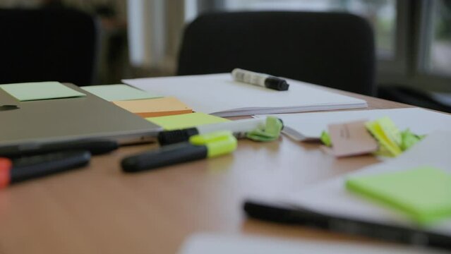 Office school table covered with paper and markers for creative idea generation in slow motion