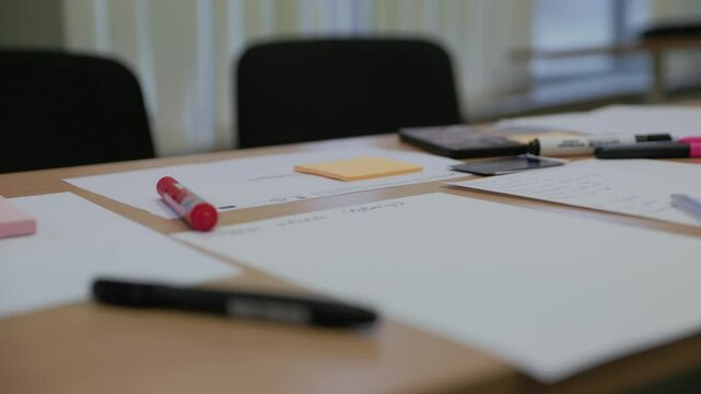 Office school table covered with paper and markers for creative idea generation in slow motion