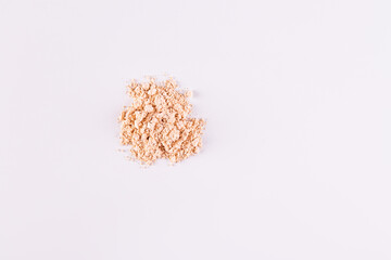 A pile of loose light powder on a white background. space for text. layout for your product. Color cosmetics texture concept. Top view.