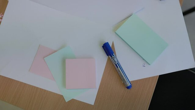 Office school table covered with paper and markers for creative idea generation in slow motion