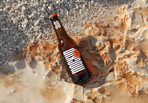 Laying Bottle on Rock Beach Mockup