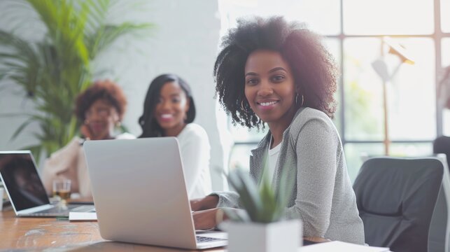 Young African American female businesswomen business start-up working with colleagues sitting in workplace, creative lady brainstorm ideas with coworkers, modern technology laptop computer home office