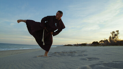 Monk athlete from a karate kick in the beach