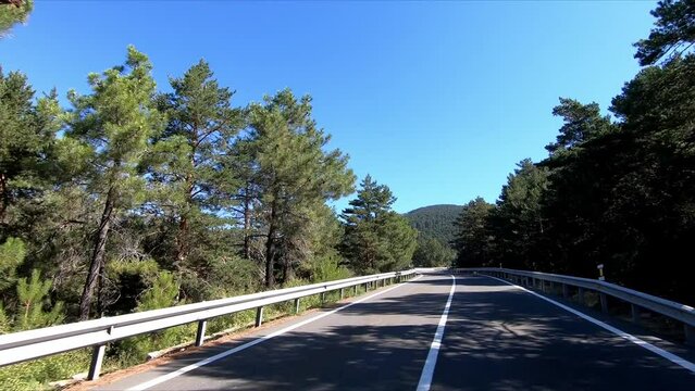 Driving in a vehicle on the mountain road near Puerto de Navacerrada in the Sierra de Guadarrama, in Madrid, Spain. Point Of View (POV), subjective view