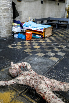 Beguinage catholic church, Brussels, Belgium. Art work symbolizing violence on migrants and homeless person&acirc;&euro;&trade;s bed