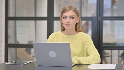 Casual Creative Woman Looking at Camera while Working on Laptop