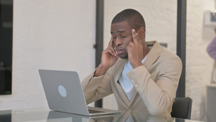 African American Man having Headache, Typing on Laptop