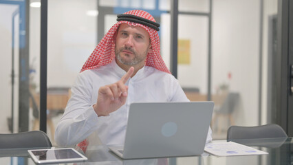 Rejecting Arab Man with Disliking Gesture at Work