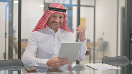 Arab Man Celebrating while Using Tablet