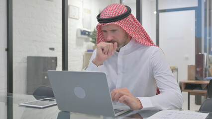 Sick Middle Aged Muslim Man Feeling Unwell at Work, Coughing