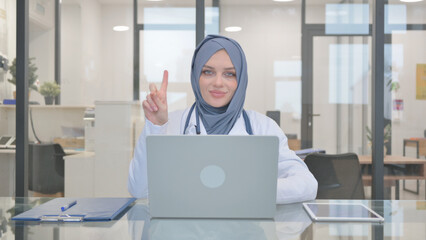 Doctor in Hijab Shaking Head in Denial while Working on Laptop