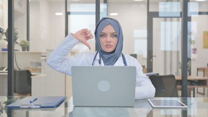 Naklejka na ściany i meble Thumb Down by Doctor in Hijab while Working on Laptop