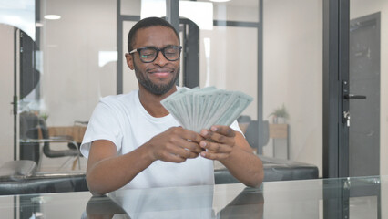 Young African Man Holding Money and Enjoying Moment