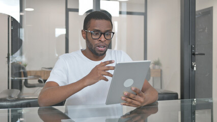 Young African Man Doing Video Chat on Tablet in Office