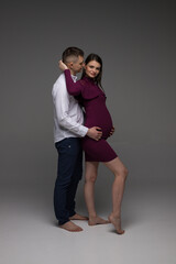 pregnant couple, pregnant couple standing on a grey background