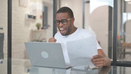 African American Man Celebrating Document Report at Work