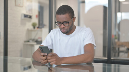 African American Man Typing Message on Phone