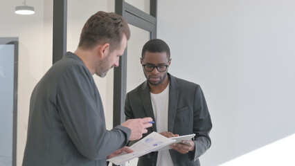 African Entrepreneur Discussing Work with Employee, Standing in Office