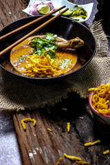 Khao Soi Recipe,Khao Soi,Khao Soi Kai, Thai Noodles Khao Soi, Chicken Curry with seasoning on wooden floor, Northern Thai food concept. (Lanna food)