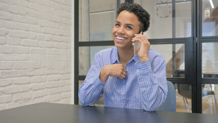 Young African Woman Talking on phone in Office