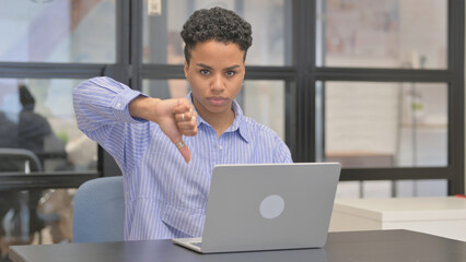 Thumbs Down by Mixed Race Woman while Using Laptop