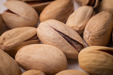 Many closed pistachios in macro close-up. Healthy food background with selective soft focus