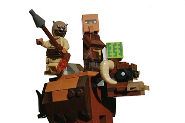 Obraz premium LEGO Tusken raider and Minecraft villager with square watermelon riding on Banthas bull mount.