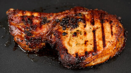 Frying bone pork steak on grill, close up