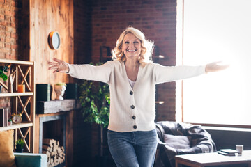 Portrait of aged lady raise opened arms welcome cuddle you wear white cardigan loft interior house indoors