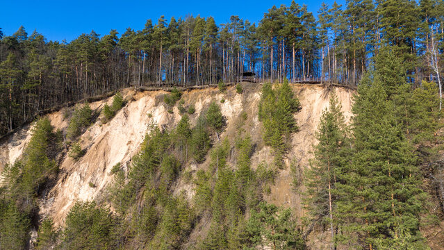 Drone photography of a small hillside erosion and trees trying growing back during springtime day
