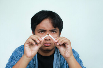 Asian man refusing cigarette concept for quitting smoking. Point to the cigarette destroy and show...