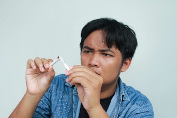 Asian man refusing cigarette concept for quitting smoking. Point to the cigarette destroy and show...