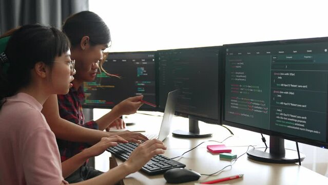 Back end software developer engineer for computer programming working together on debugging writing computing code, solving complex algorithms display on monitor in office. Burgeoning