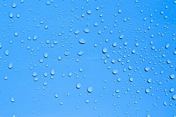 Realistic water drops on blue background or texture