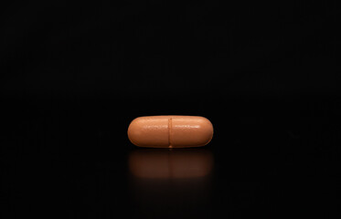 close up of an isolated pill on black background