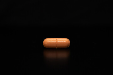 close up with a pill on a black background