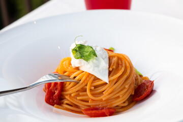 Italian pasta - spaghetti with stracciatella cheese closeup, mediterranean diet.
