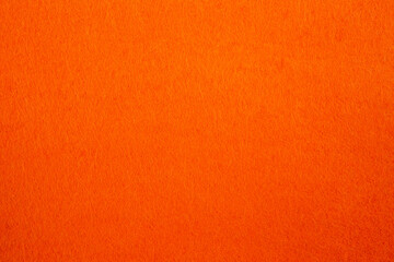 Felt fabric texture with visible fiber, orange color abstract pattern backdrop, close up