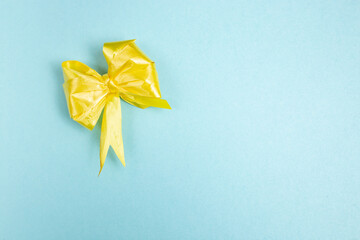 yellow crumpled ribbon on blue background, minimal greeting card layout