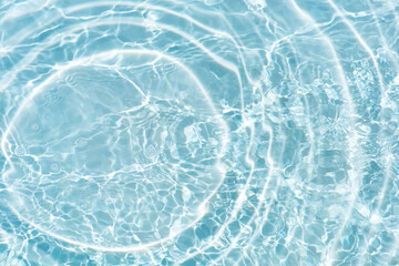 Bluewater waves on the surface ripples blurred. Defocus blurred transparent blue colored clear calm water surface texture with splash and bubbles. Water waves with shining pattern texture background.
